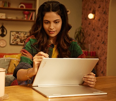 A young person working on a fully unfolded Yoga Book placeon on a desk