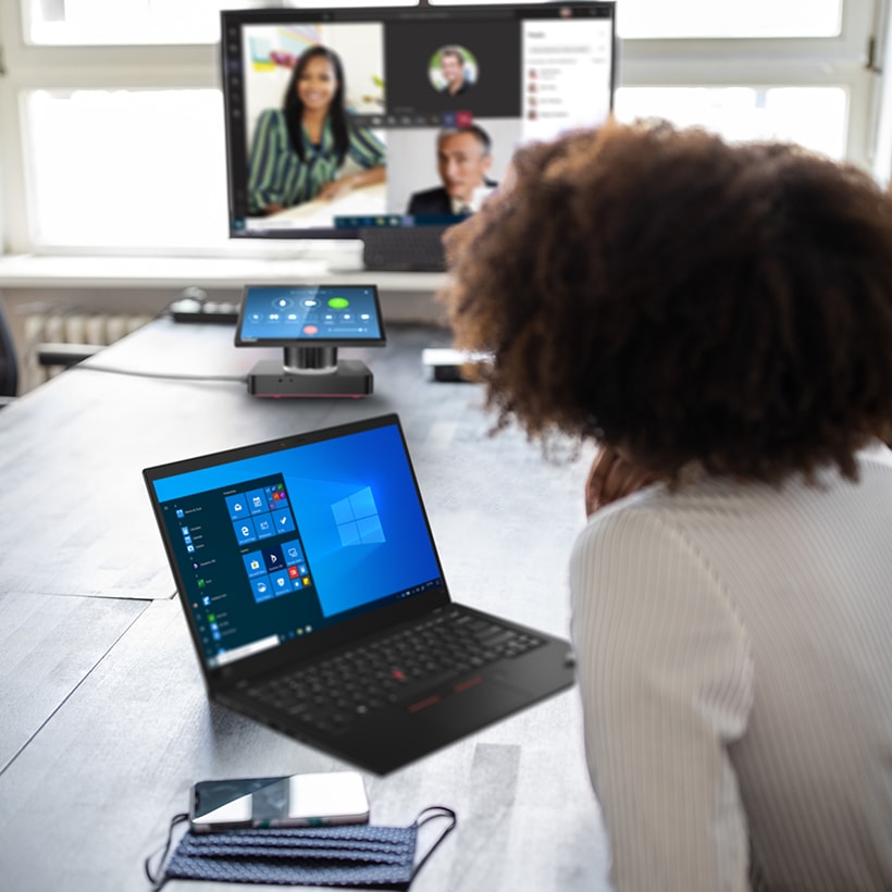 Reunión laboral con una laptop ThinkPad y más dispositivos Lenovo