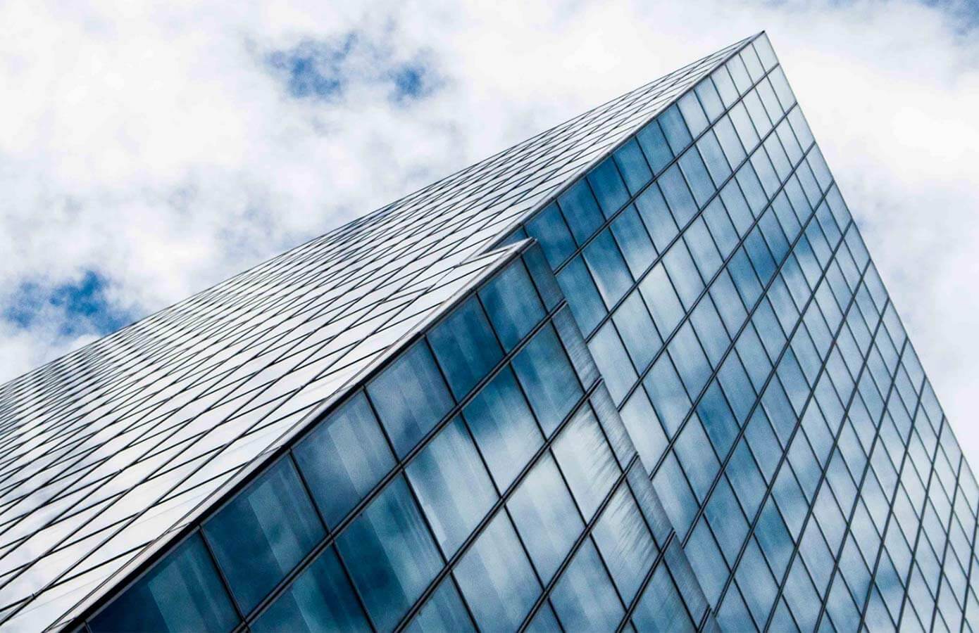 The corner of a glass office building from street level