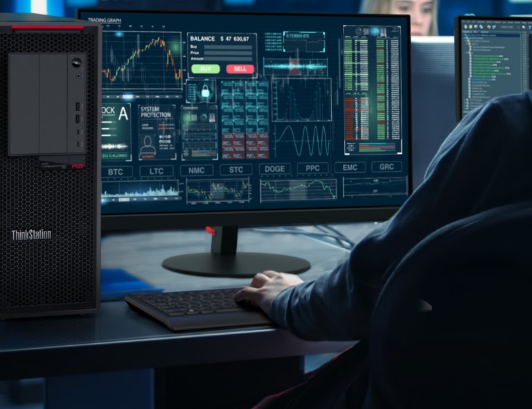 Die Lenovo ThinkStation P620 Tower-Workstation auf einem Schreibtisch mit einem Monitor, auf dem Diagramme, Grafiken und Bilanzen zu sehen sind.