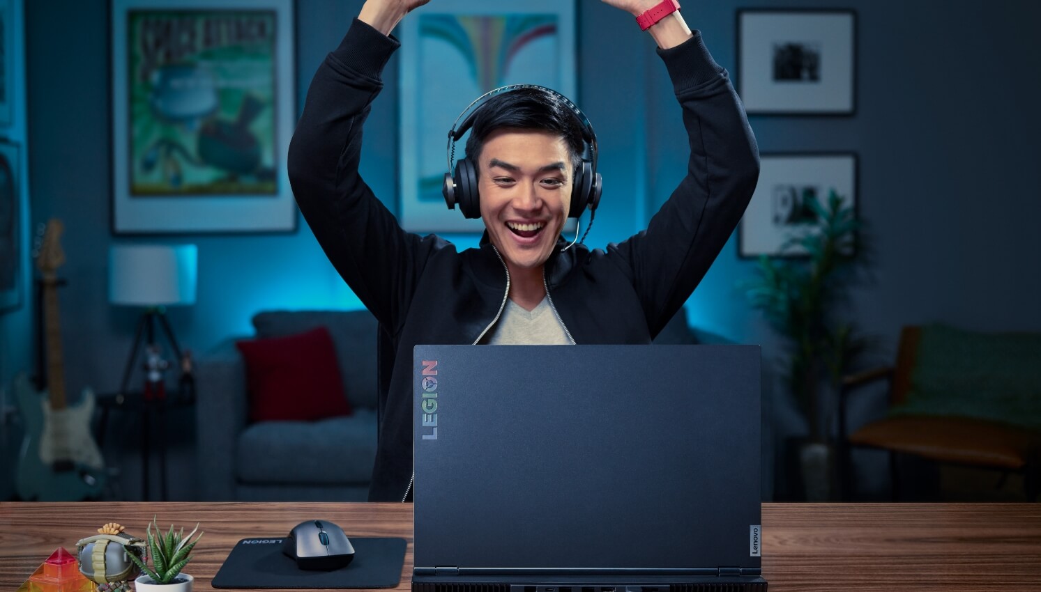 Gammer with headphones celebrate his win in front of a Laptop