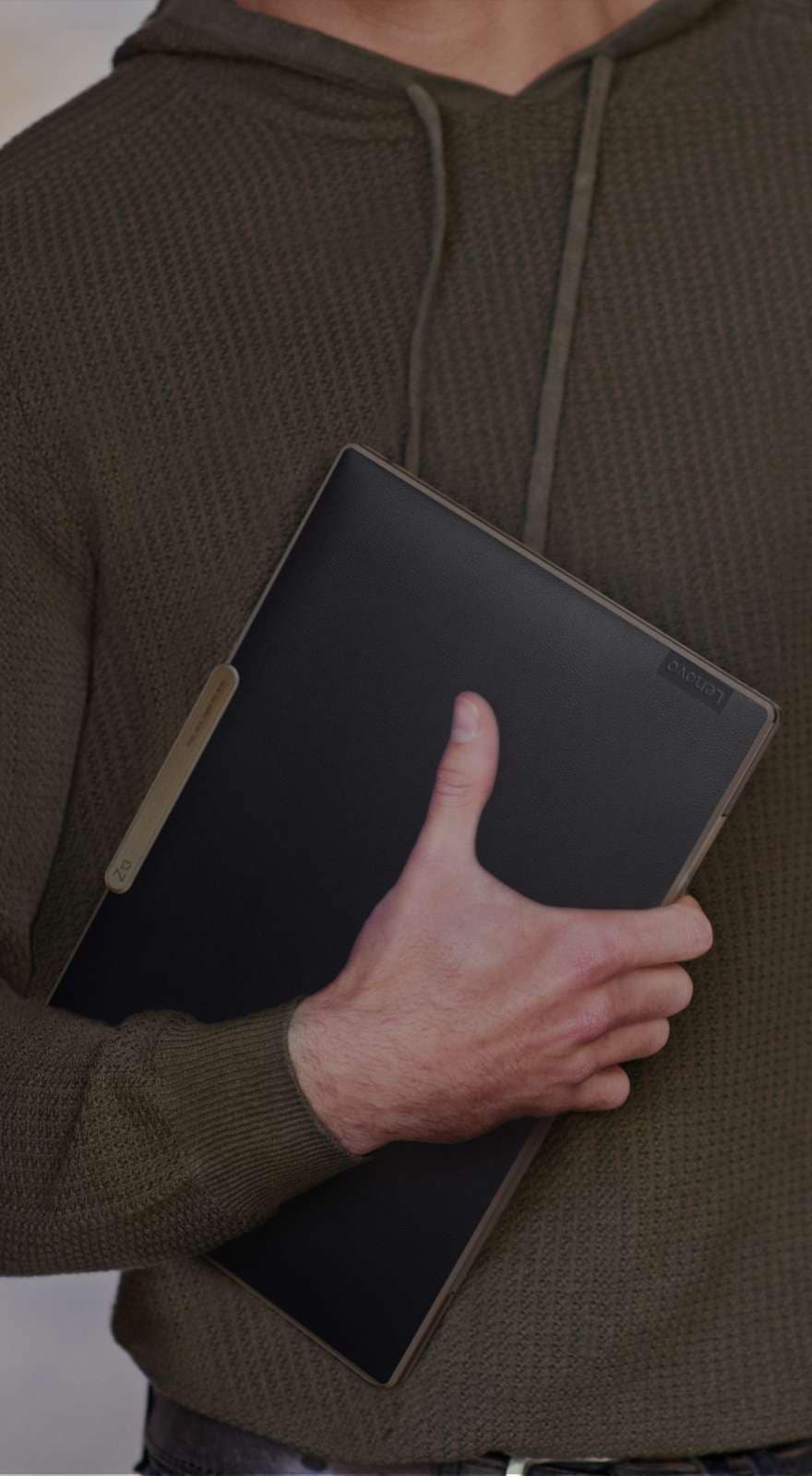 Personne portant un portable Lenovo ThinkPad Z13 en cuir recyclé noir et bronze