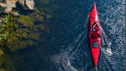 Kayaker paddling in clear water