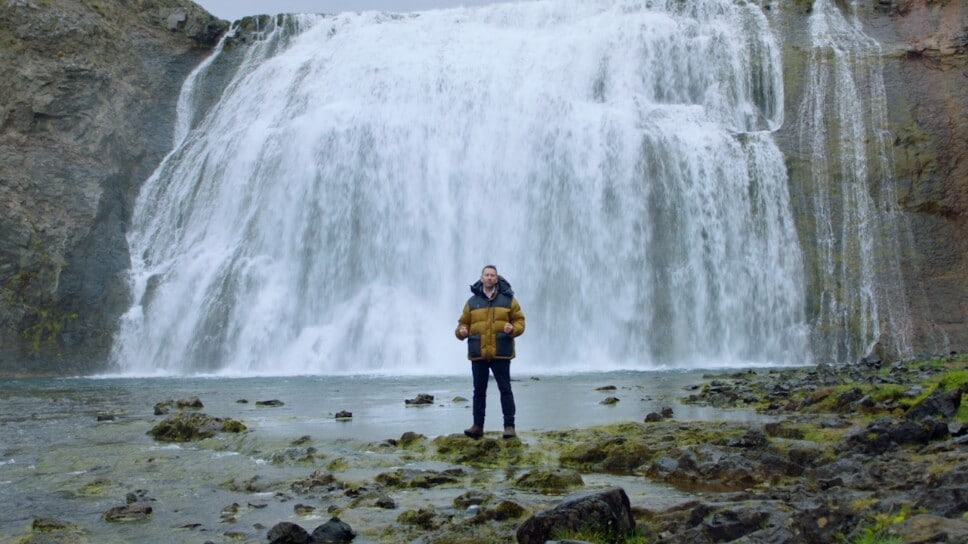 Man standing near a waterfall