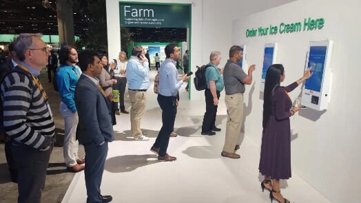 Event participants lining up at a digital kiosk