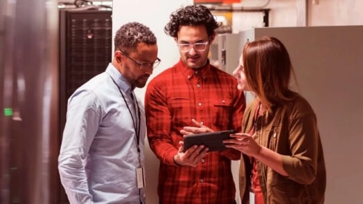 Three IT workers in a data center