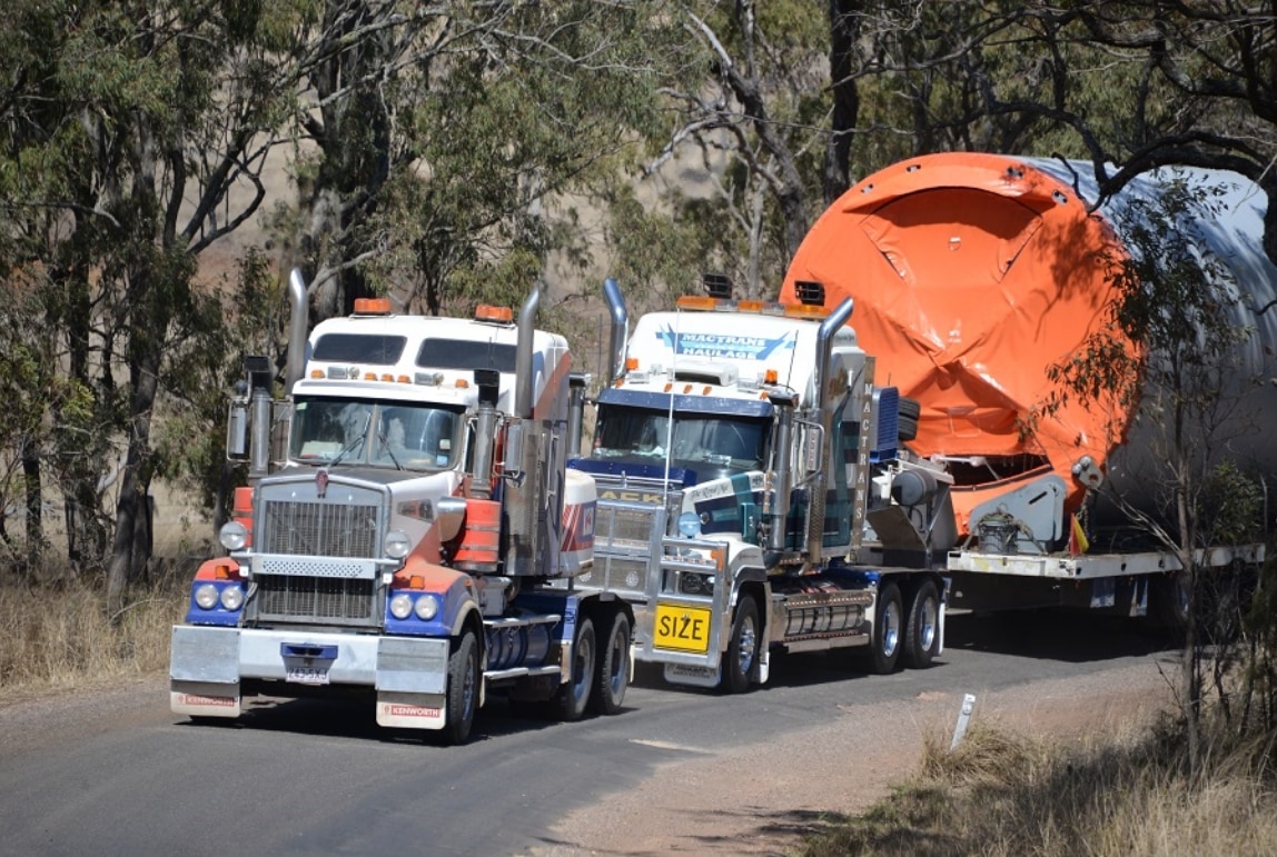 camions transportant un grand tuyau sur la route