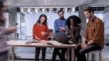 Man and woman in a conference room with ongoing video conference