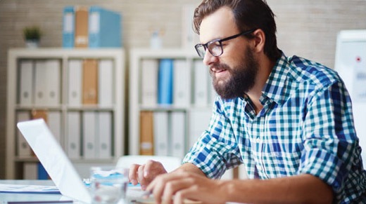 Man typing on laptop in an office