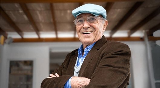 Homem sorrindo com braços cruzados