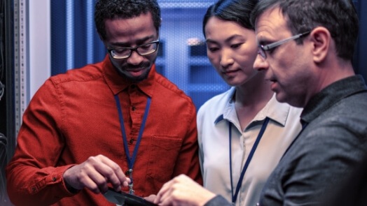 Tres personas trabajando en un centro de datos.