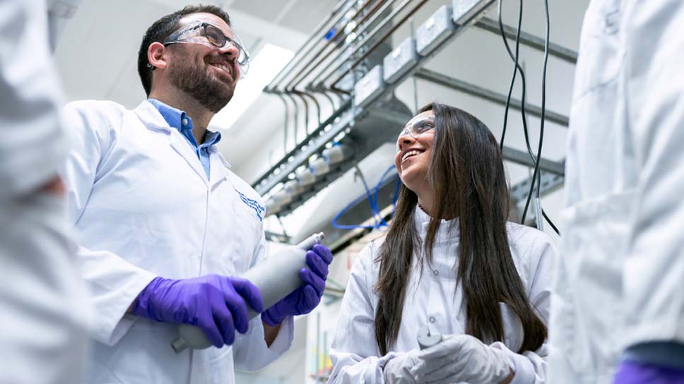 Un groupe de personnes dans un labo portant des manteaux de laboratoire