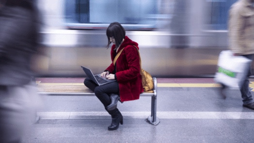 Woman working on a laptop in an urban environment