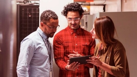 3 IT professionals collaborating in a data center