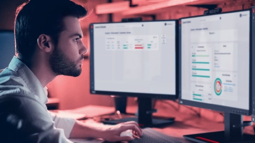 Homme au bureau avec deux moniteurs