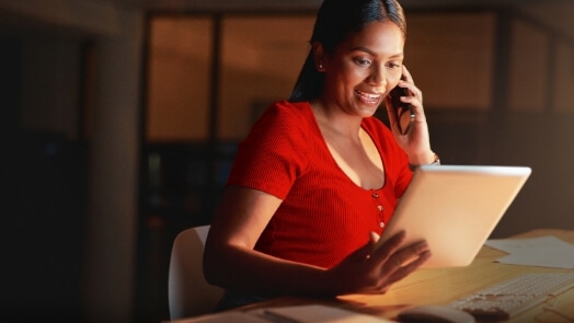 Vrouw die aan een bureau werkt met tablet en toetsenbord