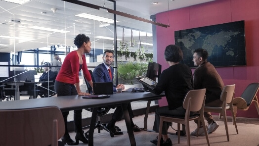 Vier IT-Mitarbeiter in einer Büroumgebung