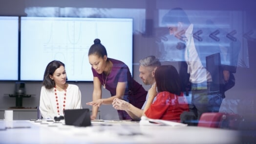 4 professionnels travaillant dans une salle de conférence